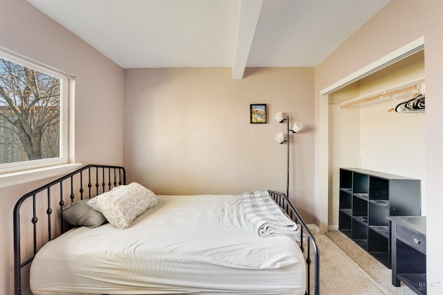 carpeted bedroom with beamed ceiling