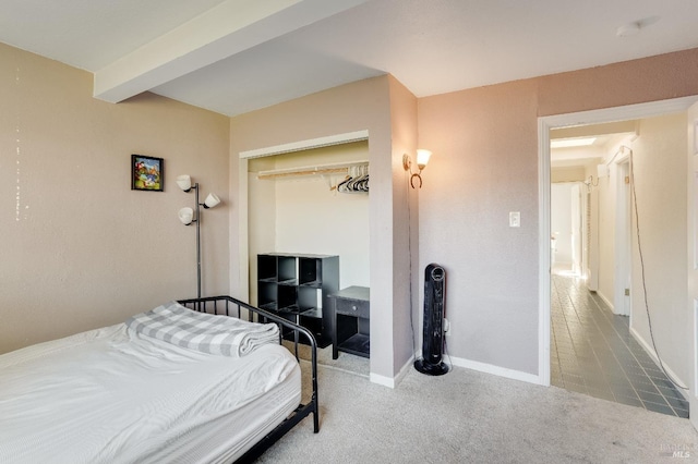 tiled bedroom featuring beamed ceiling and a closet