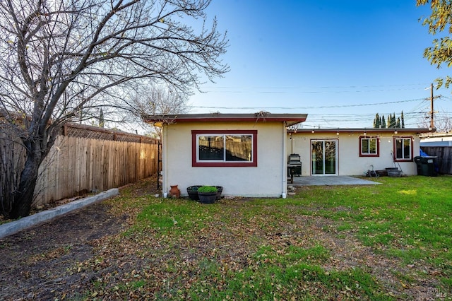 rear view of house featuring a yard and a patio area