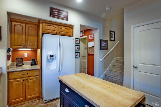 kitchen featuring white fridge with ice dispenser