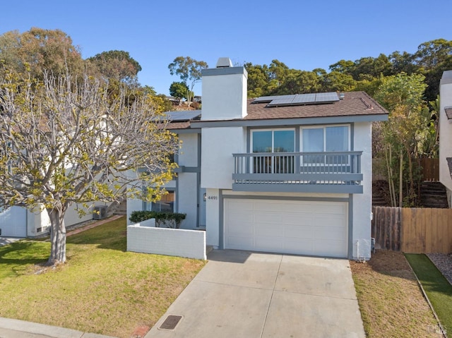 view of front of home featuring a balcony, a garage, a front yard, and solar panels