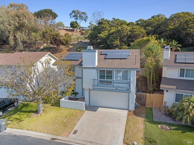 view of front property with a garage, a balcony, a front lawn, and solar panels