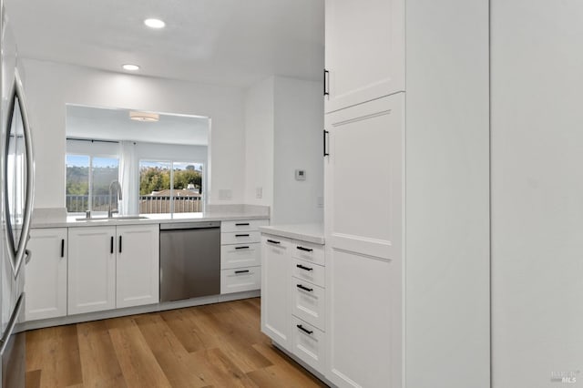 kitchen featuring white cabinetry, sink, stainless steel appliances, and light wood-type flooring