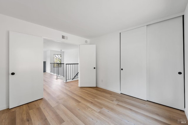 unfurnished bedroom featuring light hardwood / wood-style floors and a closet