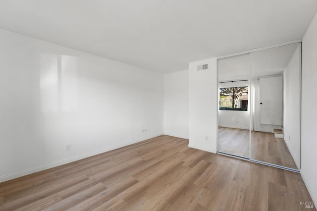 unfurnished bedroom with a closet and light wood-type flooring