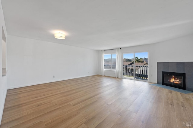 unfurnished living room featuring a fireplace and light hardwood / wood-style flooring