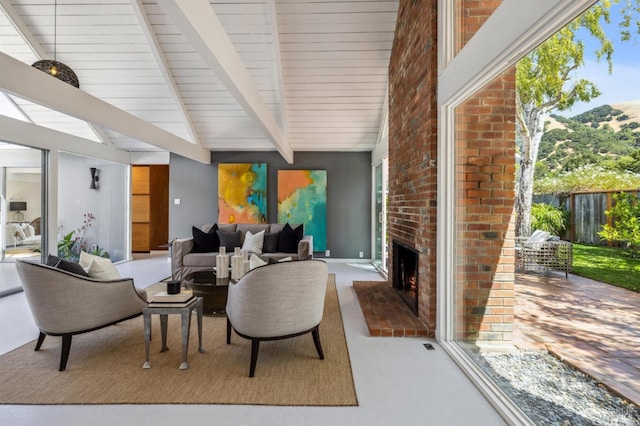 interior space with carpet floors, beamed ceiling, and a fireplace