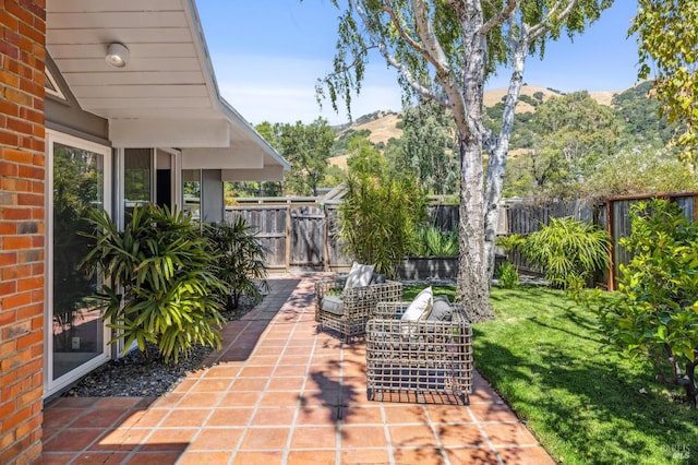 view of patio featuring a fenced backyard, a mountain view, and an outdoor hangout area