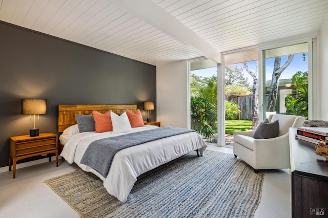 bedroom featuring access to exterior, beam ceiling, and floor to ceiling windows