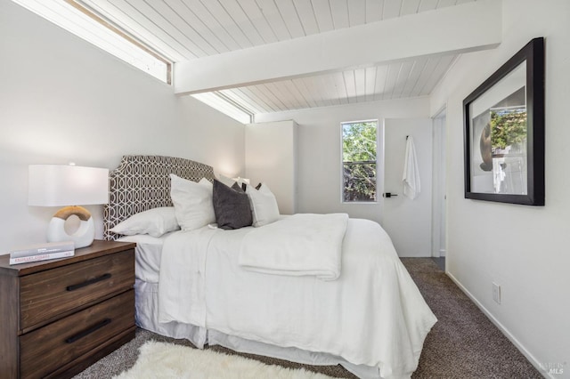 carpeted bedroom featuring beamed ceiling, wood ceiling, and baseboards