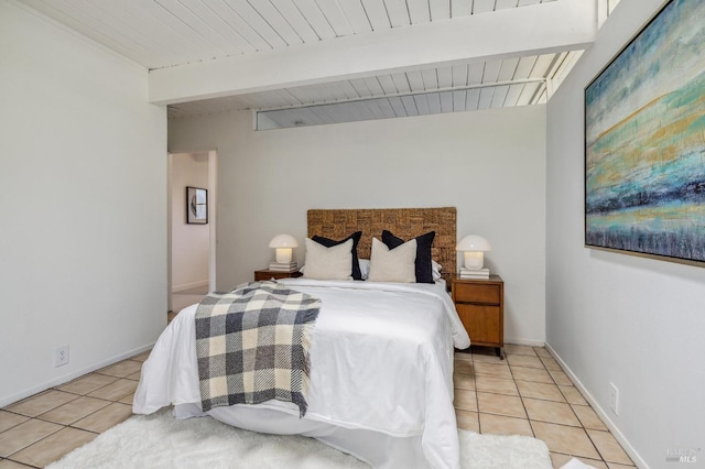 bedroom with wooden ceiling, light tile patterned floors, lofted ceiling with beams, and baseboards