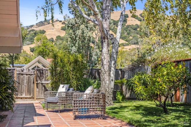 view of patio featuring a deck with mountain view and a fenced backyard