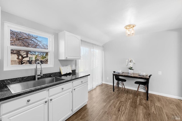 kitchen featuring a healthy amount of sunlight, sink, dark wood-type flooring, and white cabinets