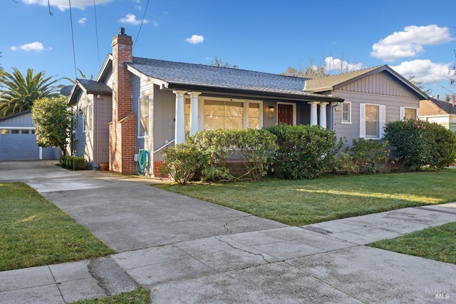 view of front of house featuring a garage, an outdoor structure, and a front yard