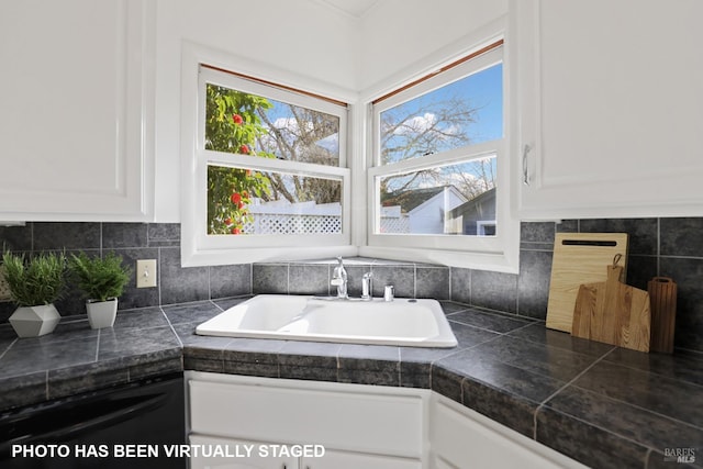 room details featuring white cabinetry, sink, decorative backsplash, and dishwasher