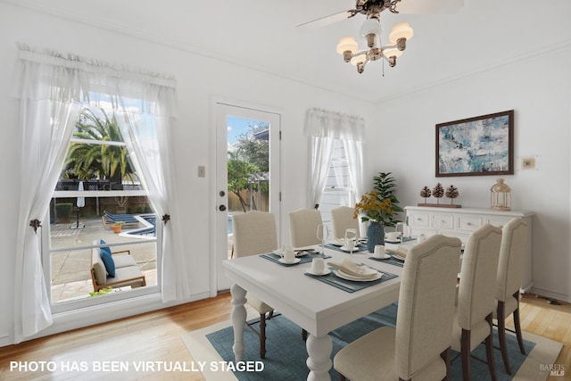 dining area with crown molding and light hardwood / wood-style flooring