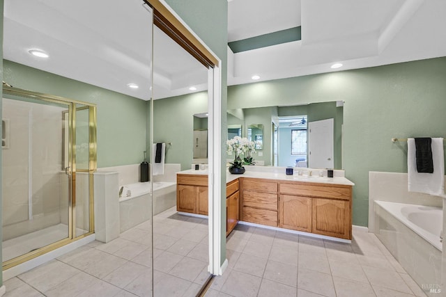 bathroom featuring a raised ceiling, vanity, and separate shower and tub