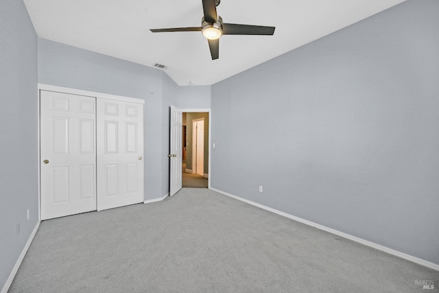 unfurnished bedroom featuring light colored carpet, ceiling fan, and a closet