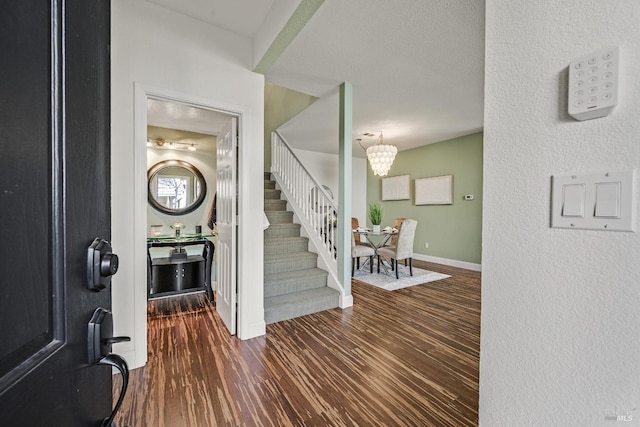 foyer entrance featuring dark hardwood / wood-style flooring and a notable chandelier