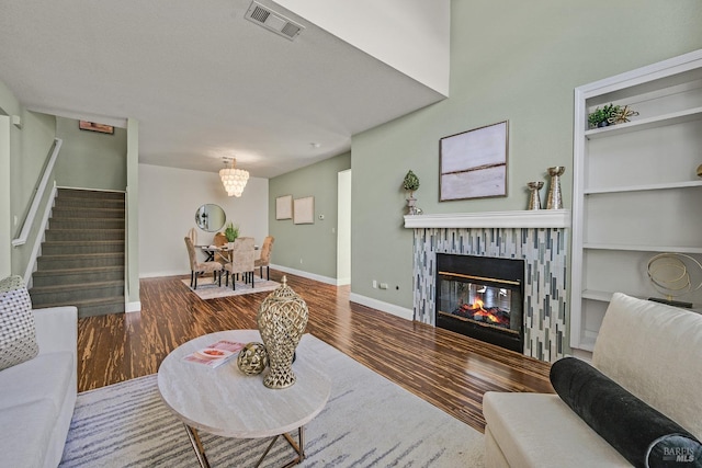 living room featuring an inviting chandelier, hardwood / wood-style floors, and built in features