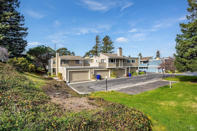 rear view of property featuring a garage and a yard