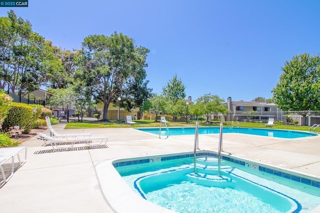 view of pool with a community hot tub and a patio area