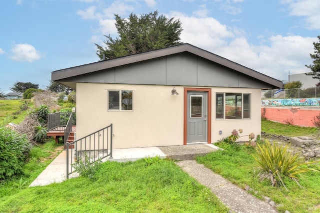 view of front of house featuring fence and stucco siding