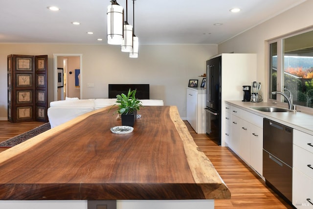 dining space featuring crown molding, sink, and light hardwood / wood-style floors