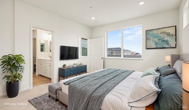 bedroom featuring light colored carpet and connected bathroom