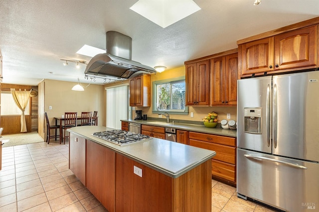 kitchen with a kitchen island, appliances with stainless steel finishes, island range hood, sink, and a textured ceiling