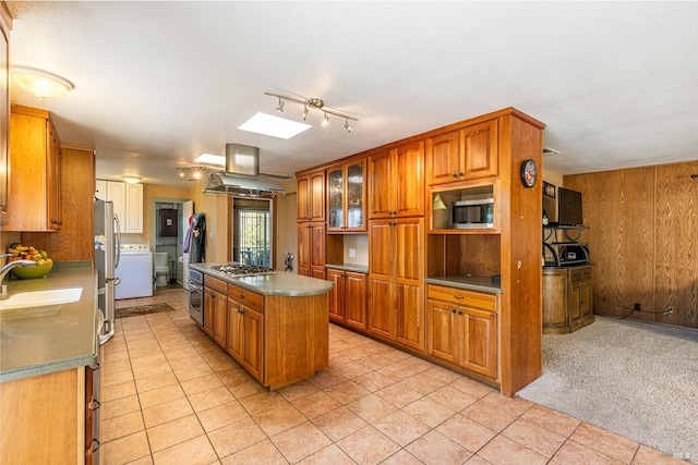 kitchen with sink, appliances with stainless steel finishes, a center island, island range hood, and light colored carpet