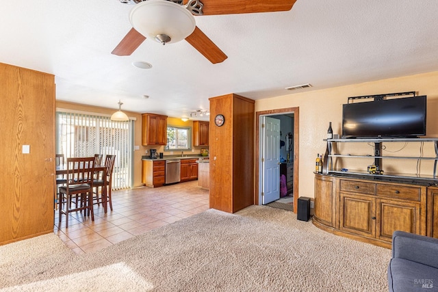 carpeted living room featuring ceiling fan and a textured ceiling