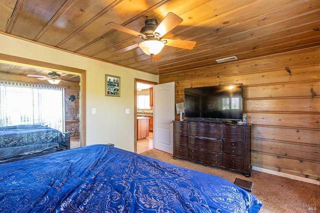 carpeted bedroom featuring ceiling fan, wood ceiling, and wood walls