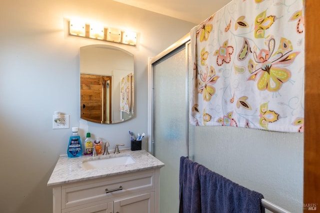 bathroom featuring walk in shower and vanity