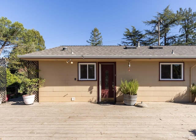 rear view of property featuring a wooden deck