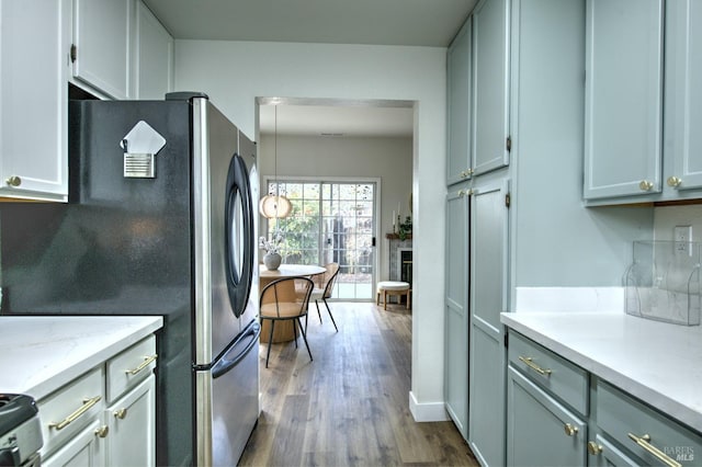 kitchen with baseboards, dark wood finished floors, a fireplace, freestanding refrigerator, and range