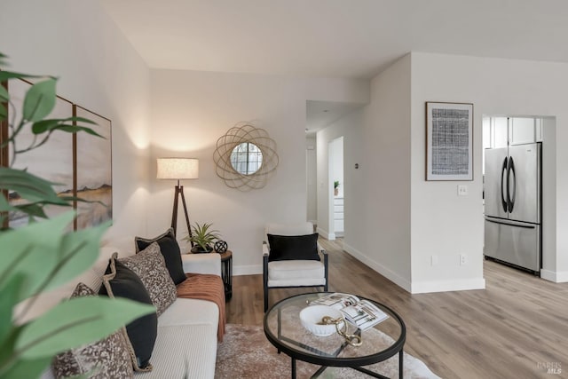 living area featuring light wood-style floors and baseboards