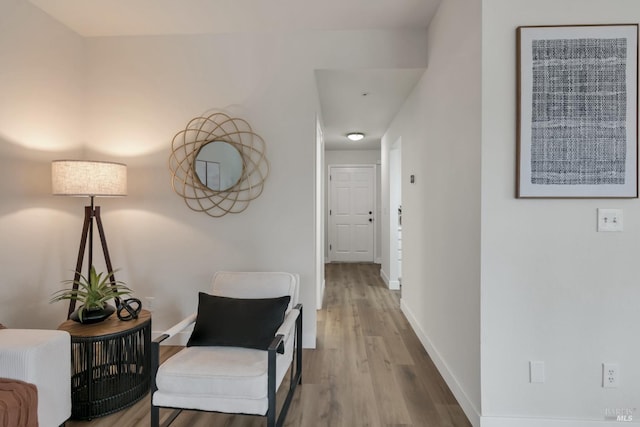 corridor with baseboards and wood finished floors