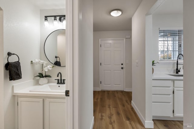 bathroom featuring baseboards, wood finished floors, and vanity