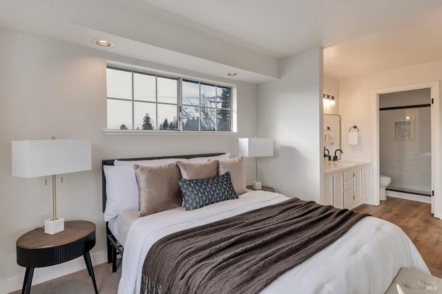 bedroom with a sink, wood finished floors, ensuite bath, and recessed lighting