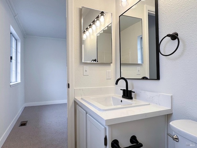 bathroom featuring visible vents, baseboards, toilet, ornamental molding, and vanity