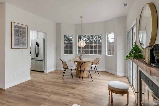 dining area with light wood-style flooring and baseboards