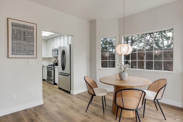 dining room with light wood-type flooring and baseboards