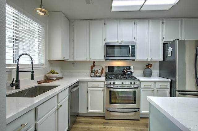 kitchen featuring a sink, stainless steel appliances, and white cabinetry