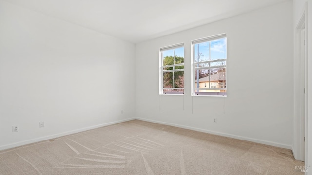 spare room featuring light colored carpet