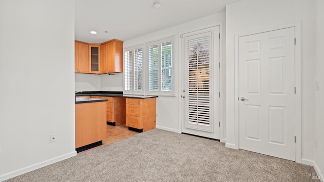 kitchen with light colored carpet and light brown cabinets