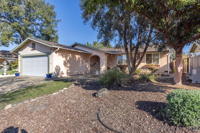 ranch-style home with fence, driveway, an attached garage, and stucco siding