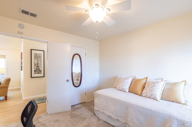 bedroom featuring light wood-style floors, baseboards, visible vents, and a ceiling fan