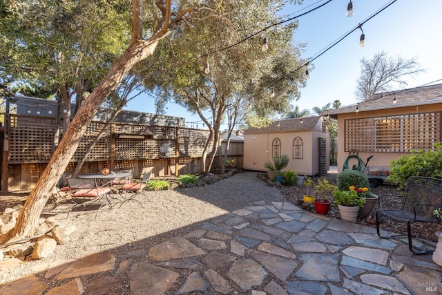 view of patio with a fenced backyard, an outdoor structure, and a storage unit