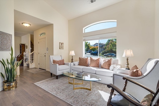 living room with dark hardwood / wood-style flooring and high vaulted ceiling